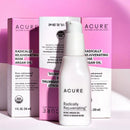 A pump bottle of ACURE Radically Rejuvenating Rose Argan Oil with its packaging box displayed against a pink & white background.