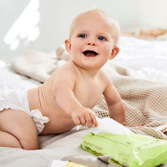 baby on a beige blanket with 100% natural baby wipes that is perfect for delicate baby skin from award winning Australian brand